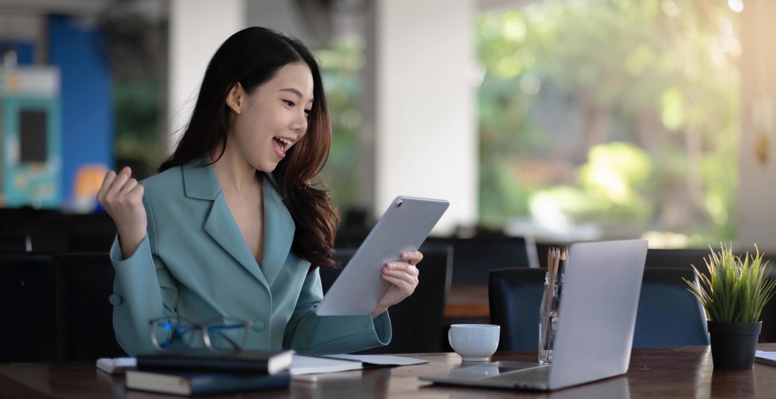 asian-business-woman-are-delighted-and-happy-with-the-work-they-do-on-their-laptop-and-taking-notes-at-the-office-free-photo-1